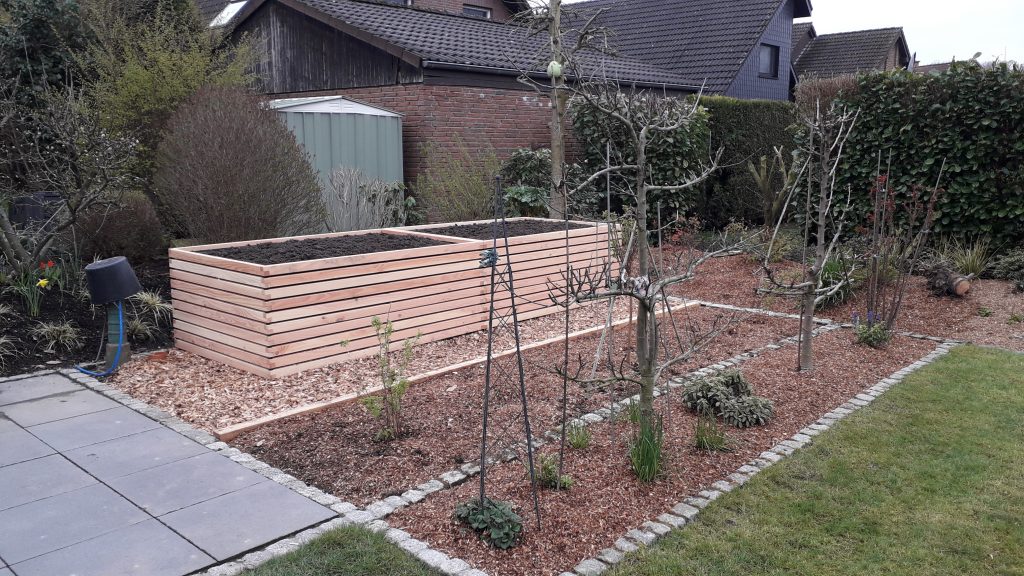 Frisch gefülltes Hochbeet im Garten des Kunden